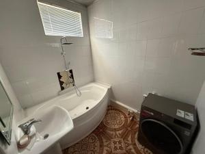 a bathroom with a tub and a sink and a toilet at The Skyline Apartments in Samarkand