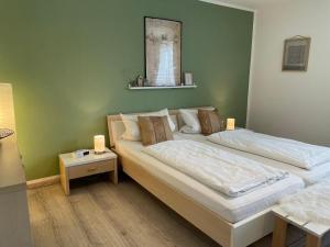 two beds in a room with green walls at Ferienwohnungen Geier in Niederalteich