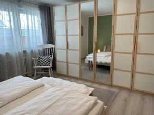 a bedroom with a mirror and a bed and a chair at Ferienwohnungen Geier in Niederalteich