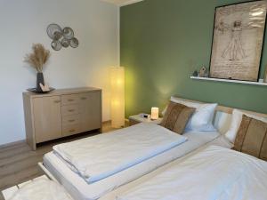a bedroom with two beds and a dresser in it at Ferienwohnungen Geier in Niederalteich