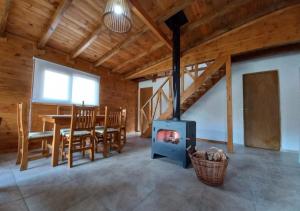 a living room with a wood stove and a table at Complejo Maylen Meliquina in Lago Meliquina +1 photo