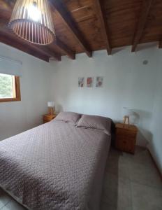 a bedroom with a bed and two pendant lights at Complejo Maylen Meliquina in Lago Meliquina