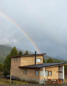 a large wooden house with a black roof at Complejo Maylen Meliquina in Lago Meliquina