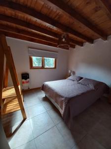 a bedroom with a bed and a window at Complejo Maylen Meliquina in Lago Meliquina