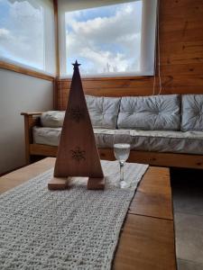 a living room with a christmas tree and a wine glass at Complejo Maylen Meliquina in Lago Meliquina