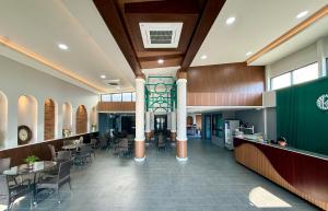a restaurant with tables and chairs and a staircase at KYP Hotel โรงแรมขุนยูวเพลส in Fang