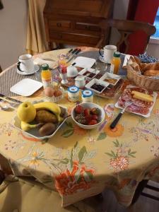 a table with fruits and other food on it at Chambre Cosy Eaubonne in Eaubonne +8 photos