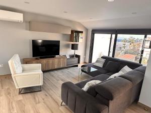 a living room with a couch and a flat screen tv at Villa Mirlo Seaview in Palm-Mar