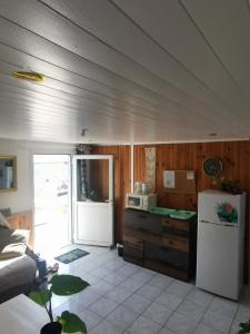 a kitchen with a white refrigerator and a microwave at KaZen chez Steph in Petite Île