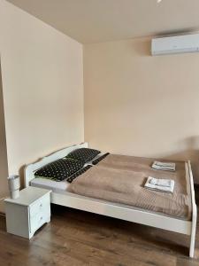 a bedroom with a white bed and a night stand at Szántó Prime Residence in Szolnok