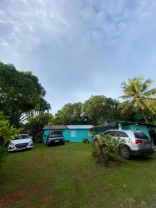 two cars parked in front of a blue house at Casa de Campo Vive in Ensanche Savica de Mendoza