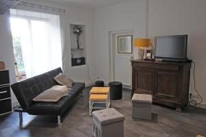 a living room with a couch and a tv at De pelage in Saint-Just-le-Martel