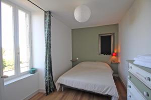 a small bedroom with a bed and a window at De pelage in Saint-Just-le-Martel +13 photos