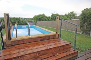 a wooden deck with a plunge pool with a metal railing at De pelage in Saint-Just-le-Martel