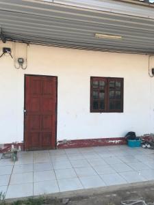 a red door and two windows on a white wall at Yada House in Nong Ki