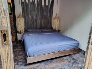 a bed with a wooden headboard in a bedroom at Jagad Villa with 3 Bedroom in Ungasan