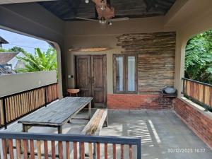 a porch with a wooden table and a bench at Jagad Villa with 3 Bedroom in Ungasan