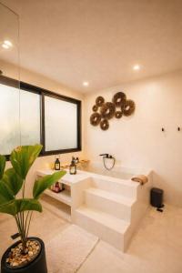a bathroom with a white bath tub and a plant at Villa Nomada Exclusive Modern Seaview Spa and Wellness Villa with Daily Housekeeping 5 Bedrooms Sauna Ice Bath and 20 Meter Private Saltwater Pool in Ban Bang Po +39 photos