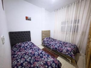 a bedroom with two beds and a window at Appartement Ettahrir in Tunis