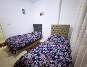 two beds sitting next to each other in a room at Appartement Ettahrir in Tunis +6 photos