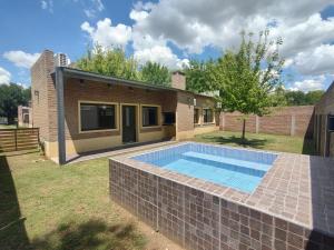 a swimming pool in a yard next to a house at Las Arecas in Carmen de Areco