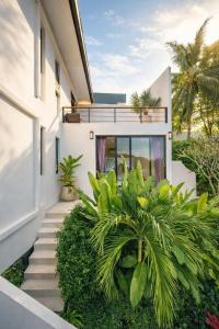 a staircase leading to a house with palm trees at Villa Nomada Exclusive Modern Seaview Spa and Wellness Villa with Daily Housekeeping 5 Bedrooms Sauna Ice Bath and 20 Meter Private Saltwater Pool in Ban Bang Po