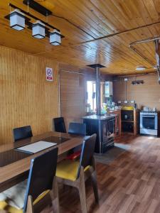 a dining room with a table and a kitchen at Cabaña Cielo Patagonico in Futaleufú