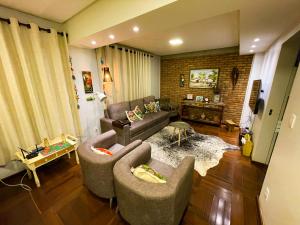 a living room with a couch and two chairs at Pousada Real in Caldas Novas
