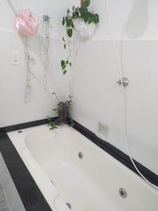 a bathroom with a bath tub with a plant in it at Casa das Plantas in Piraju