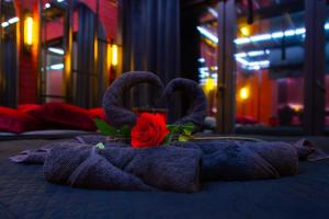 a towel with two swans on a bed with a rose at Love Apartament z sauną i jacuzzi in Katowice