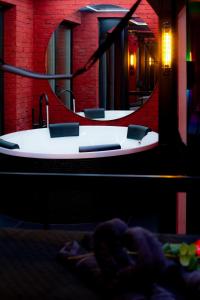 a bath tub with a sink and a mirror at Love Apartament z sauną i jacuzzi in Katowice