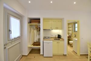 a kitchen with white cabinets and a sink and a window at Sterna Apartment in Hydra