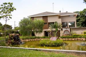 a house with a pond in front of it at Pousada Real in Caldas Novas