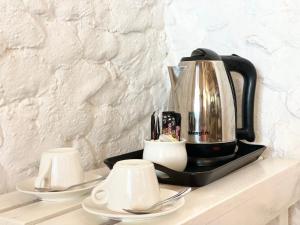 a coffee maker sitting on top of a counter with two cups at HA Beach Breeze in Jambiani