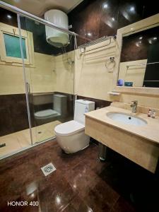 a bathroom with a toilet and a sink and a shower at فندق جولدن روز Golden Rose Hotel in Jazan +15 photos