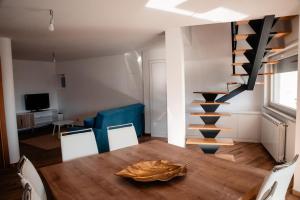 a dining room with a table and a spiral staircase at Casa da avo Rita in Pêro Viseu