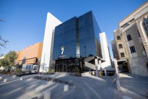 a large glass building in the middle of a street at 7Crown Tahliah Hotel in Riyadh