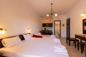 a bedroom with two beds and a dining room at Casa di Dandolo in Parga
