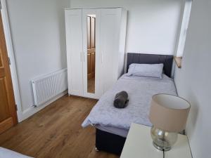 a bedroom with a bed and a table with a lamp at Silver Strand Chalets - Chalet 2 in Malin Beg