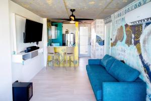 a living room with a blue couch and a tv at Ocean view condo with pool & fits 3 in Fajardo