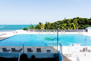 a large swimming pool next to the ocean at Ocean view condo with pool & fits 3 in Fajardo