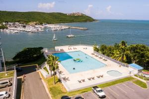 an overhead view of a swimming pool next to a body of water at Ocean view condo with pool & fits 3 in Fajardo
