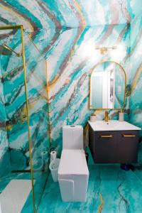 a bathroom with a painting on the wall at Ocean view condo with pool & fits 3 in Fajardo +10 photos