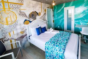 a bedroom with a bed in a room with a mural at Ocean view condo with pool & fits 3 in Fajardo