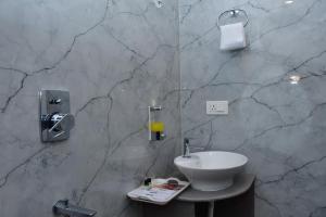 a bathroom with a sink and a marble wall at Hotel Devi Palace in Rājgīr