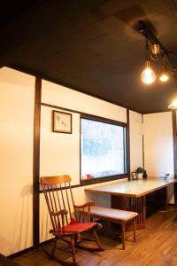 a room with a chair and a table and a window at Zaō Hütte 一棟貸し in Zao
