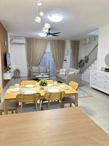 a dining room and living room with a table and chairs at Voila PD Homestay in Lukut