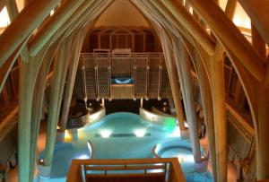 a swimming pool in a building with an archway at Spacious, bright and comfortable bedrooms in Lannemezan