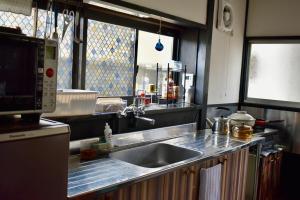a kitchen with a sink and a microwave at Zaō Hütte 一棟貸し in Zao +52 photos