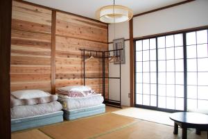 two beds in a room with a wooden wall at Zaō Hütte 一棟貸し in Zao